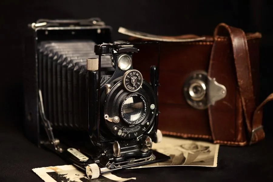 camara antigua estilo photocall para eventos sobre una mesa y fotos