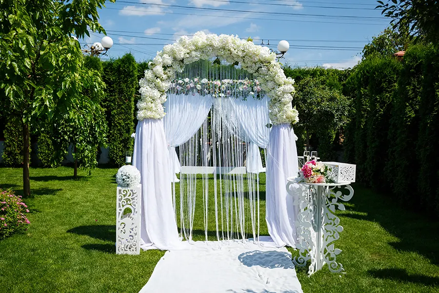 Candy bar de boda con macarons, vasitos de postre y dulces variados sobre mesa rústica decorada